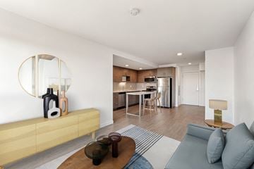 Seattle apartment for rent - A modern living room with a wooden coffee table and a large mirror on the wall.