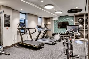 Washington apartment for rent - a gym with treadmills and bikes and a tv on the wall