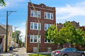 Chicago apartment for rent - a brick apartment building with a car parked in front of it