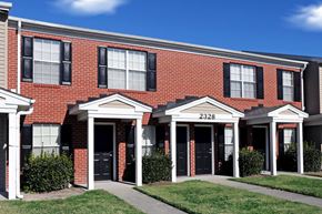 Portsmouth apartment for rent - the front of a brick building with black windows and a sidewalk