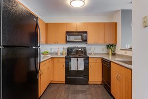 Worcester apartment for rent - a kitchen with black appliances and wooden cabinets