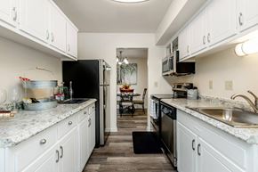 Blacksburg apartment for rent - a kitchen with white cabinets and a black refrigerator