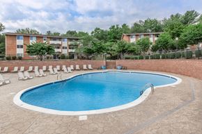 Blacksburg apartment for rent - a swimming pool with chairs around it in front of an apartment building