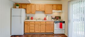Edgewood townhouse for rent - a kitchen with wooden cabinets and a white refrigerator
