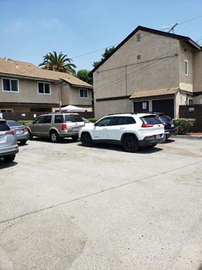 Los Angeles apartment for rent - a parking lot filled with cars in front of a building