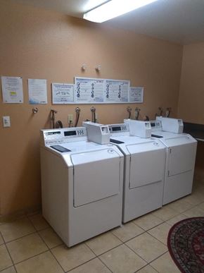Los Angeles apartment for rent - four washing machines in a room with signs on the wall