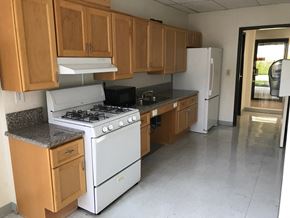 Reseda apartment for rent - an empty kitchen with white appliances and wooden cabinets