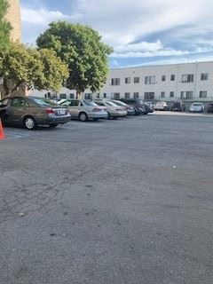 Los Angeles apartment for rent - a parking lot filled with cars in front of a building