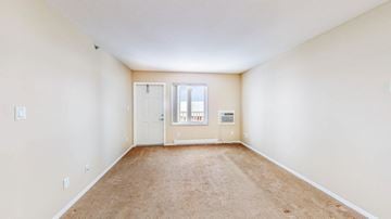 Brandon apartment for rent - a spacious living room with white walls and carpet