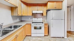 Brandon apartment for rent - a kitchen with white appliances and wooden cabinets