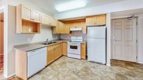 Brandon apartment for rent - a kitchen with white appliances and wooden cabinets