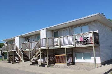 Brandon triplex for rent - the exterior of an apartment building with stairs and a balcony