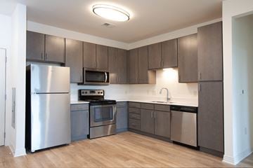 Charlottesville apartment for rent - A kitchen with a refrigerator, microwave, oven, and sink.