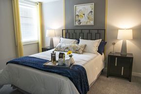 Schaumburg apartment for rent - a bedroom with a bed and a tray with flowers on it