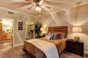 Houston apartment for rent - a bedroom with a bed and a ceiling fan