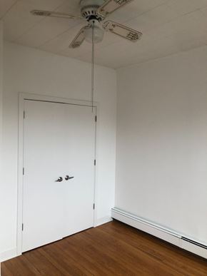 Jersey City apartment for rent - a bedroom with a white door and a ceiling fan