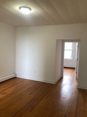 Jersey City apartment for rent - an empty living room with white walls and wooden floors