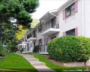 North Plainfield apartment for rent - A white building with a balcony and a green bush in front.