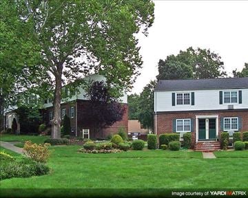 Fair Lawn apartment for rent - A white house with green shutters and a tree in front.