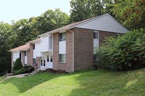 Scranton apartment for rent - a white and brick house with a yard and trees