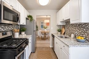 Silver Spring apartment for rent - A kitchen with white cabinets and a black stove top oven.