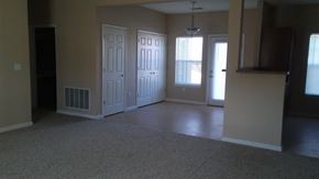 Kokomo townhouse for rent - an empty living room with two doors and a carpeted floor