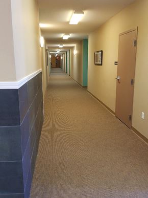 Logansport apartment for rent - a hallway in a building with a carpeted floor and doors