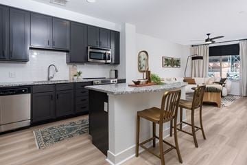Denver apartment for rent - A kitchen with black cabinets and a white island.