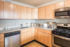 Chicago apartment for rent - a kitchen with stainless steel appliances and wooden cabinets