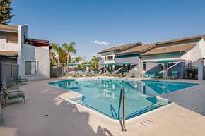Santa Ana townhouse for rent - a large swimming pool with chairs and umbrellas