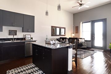 Denton apartment for rent - a kitchen with an island and a living room with a table and chairs
