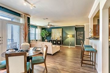 Irving apartment for rent - A dining room with a table set for two and chairs with green cushions.