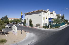 Las Vegas apartment for rent - a white building with flags and a street in front of it