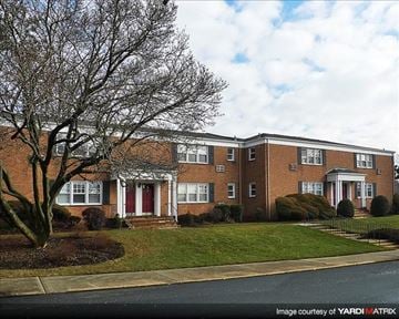 Suffern apartment for rent - A brick apartment building with a tree in front.