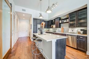 Dallas apartment for rent - a kitchen with a white counter top and dark cabinets
