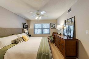 Boca Raton apartment for rent - A bedroom with a bed, dresser, and window with blinds.