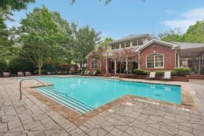 Decatur apartment for rent - A pool surrounded by a brick patio and a house in the background.