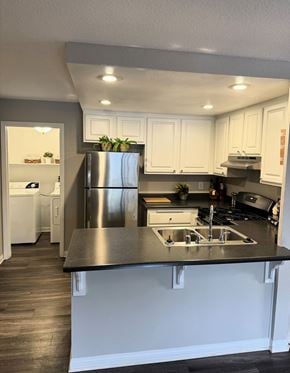 Murrieta apartment for rent - A kitchen with white cabinets and a black countertop.