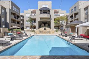 Dallas apartment for rent - a swimming pool with an apartment building in the background