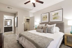 Austin apartment for rent - A bedroom with a large bed and a ceiling fan.