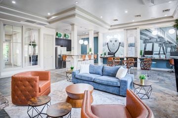 Jacksonville apartment for rent - A living room with a blue couch and orange chairs.