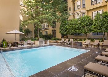Tuscan resort style pool with tanning deck and grilling area