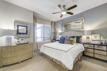 Dallas apartment for rent - a bedroom with a large bed and a ceiling fan