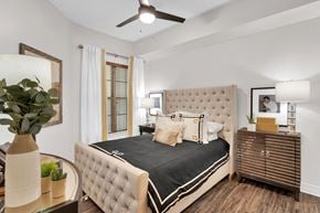 Dallas apartment for rent - a bedroom with a large bed and a ceiling fan