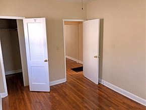Raleigh apartment for rent - an empty bedroom with three doors and a wood floor