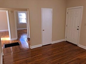 Raleigh apartment for rent - an empty living room with wooden floors and white doors