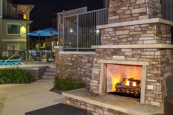 Poolside fireplace and alfresco grilling area with seating