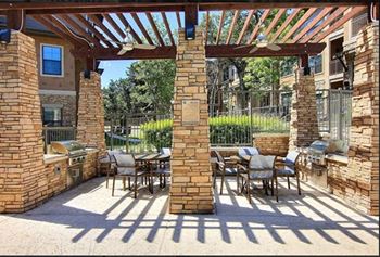 Poolside fireplace and alfresco grilling area with seating