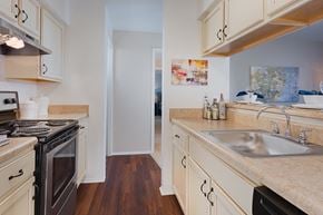 Woodbridge apartment for rent - a kitchen with white cabinets and a sink and a stove