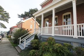 San Francisco triplex for rent - a row of brick homes with white porch railings on a sidewalk